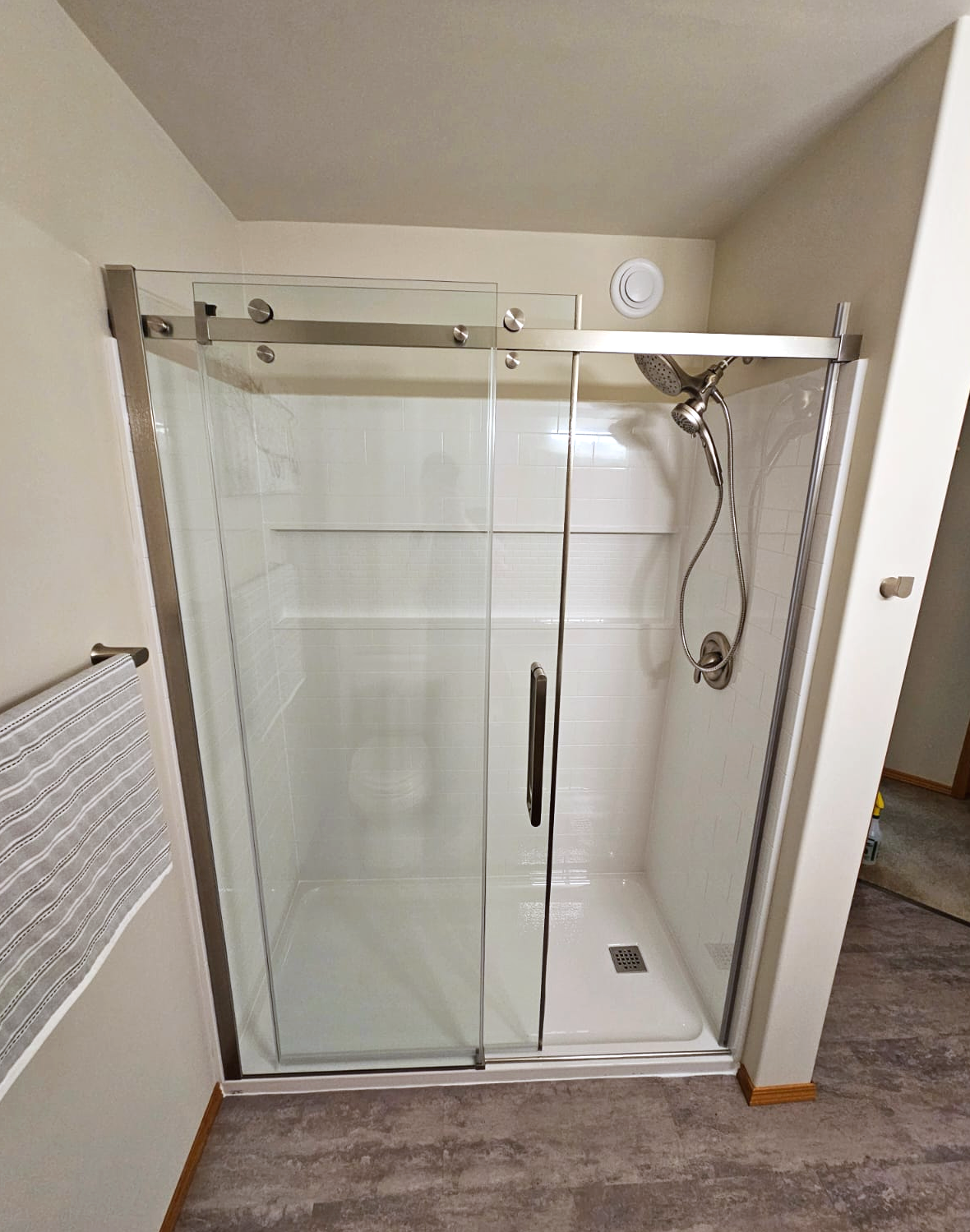 Completed bathroom renovation in St. Andrews featuring a modern walk-in shower with sliding glass doors and a low-profile base.